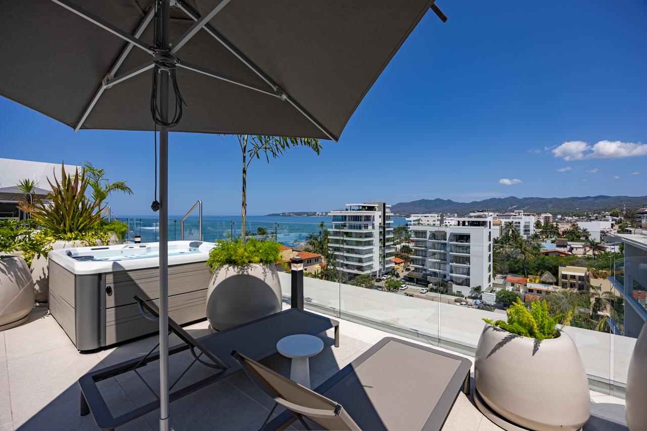 Rooftop jacuzzi with umbrella and ocean view