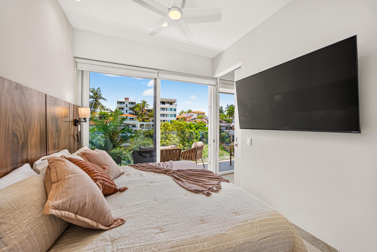 Bedroom at Casa Nayah with wall-mounted TV and balcony view