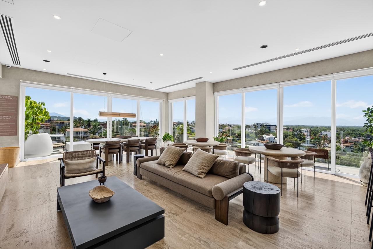 Clubhouse lounge with floor-to-ceiling windows opening to Banderas Bay