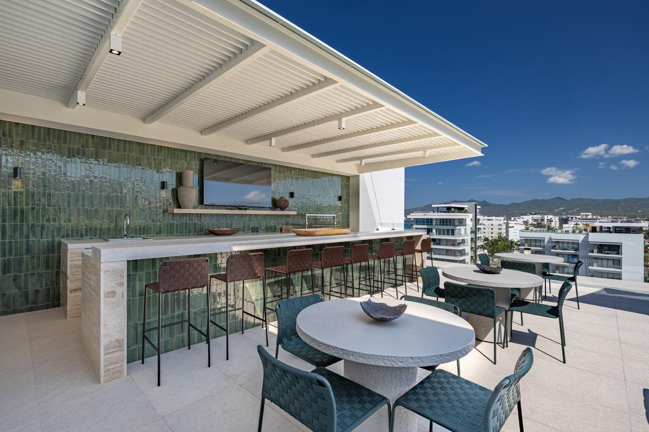 Rooftop bar with emerald tile and pergola shade over ocean views